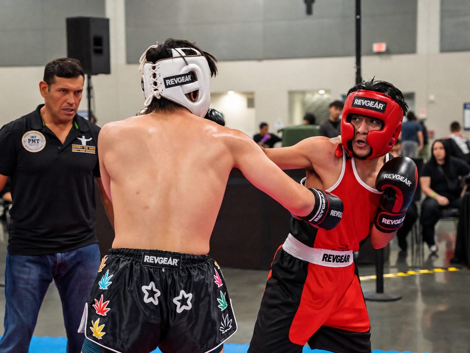 Two PBSC athletes trading punches with the referee alongside